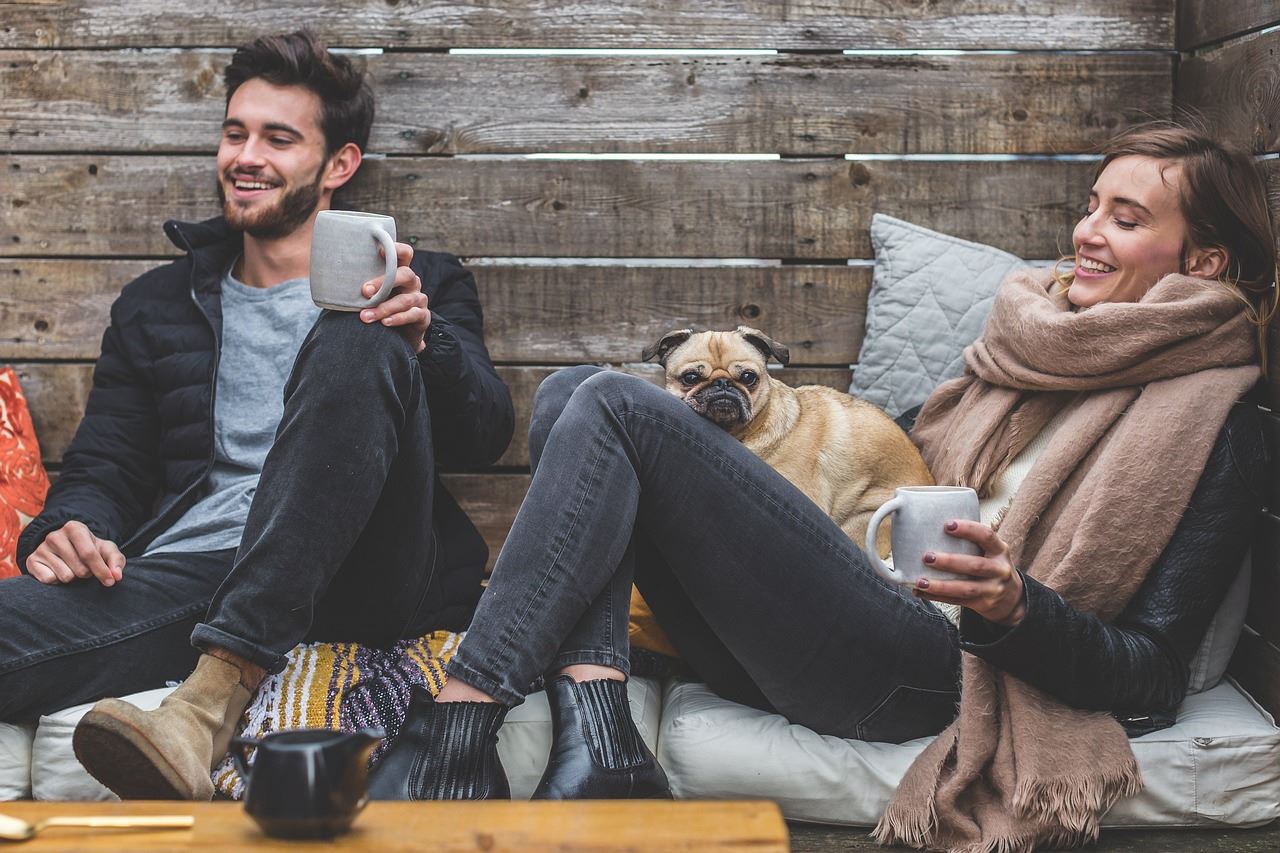 man and woman sitting together with a dog